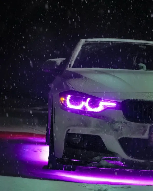 BMW with illuminated purple headlights on a snowy night with purple under-body RGB lights/underglow fast and furious lights