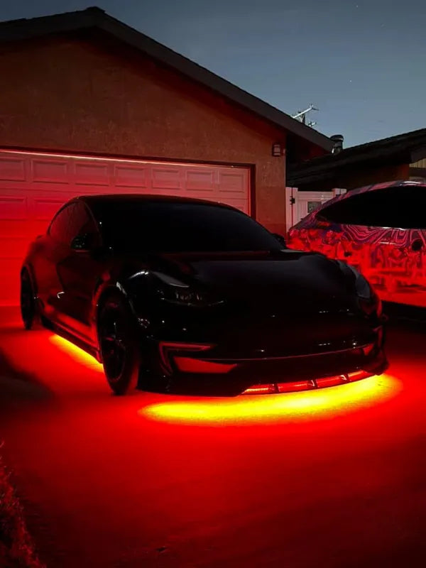 tesla model 3 Car with red underglow lights in a driveway at night