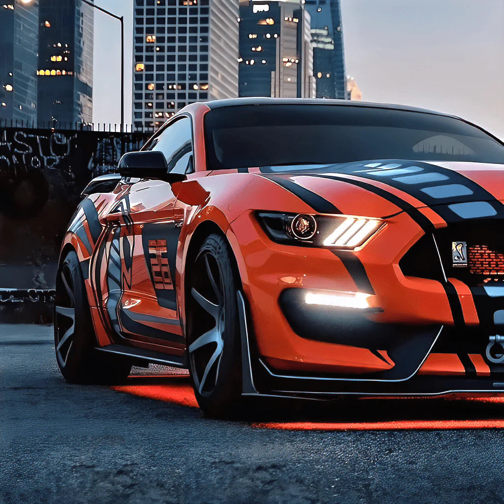 Orange and black sports car mustang shelby gt in an urban setting with underbody RGB lights/underglow 