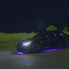 car driving with Underglow lighting kit on like fast and furious. showcasing colourchasing pattern on the road as the car drives forward 