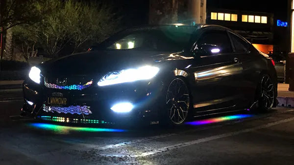 Black car with colorful underglow on a street at night with rainbow under-body RGB lights/underglow fast and furious lights 