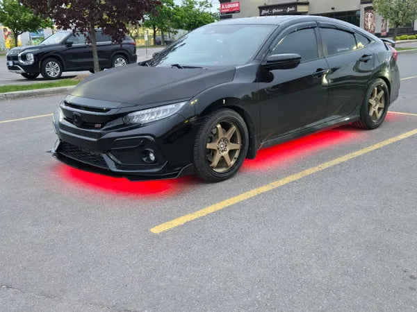Black car with gold rims on a street with under-body RGB lights/underglow fast and furious lights 