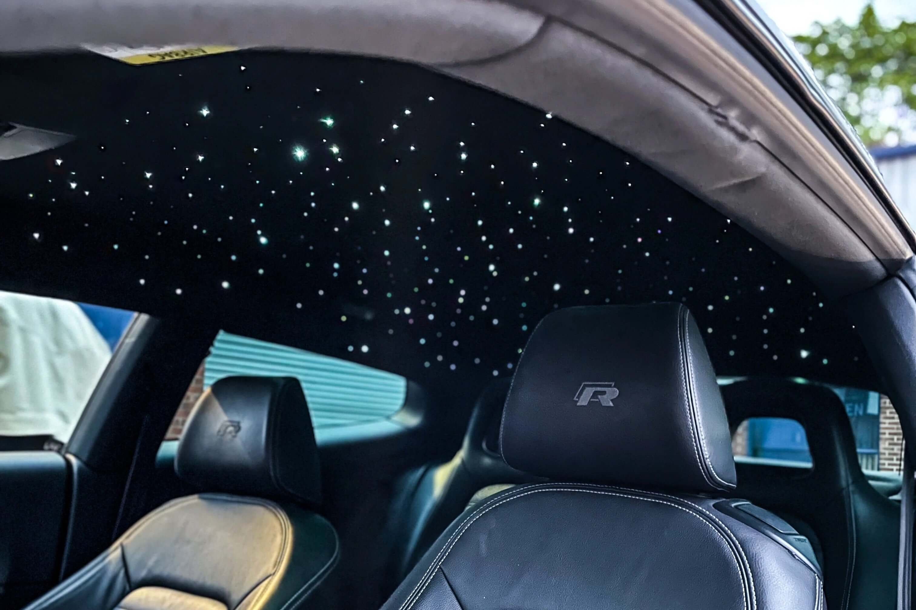 Custom starlight headliner kit featuring white fiber optic stars installed in Volkswagen Golf R interior with black leather R-logo sport seats